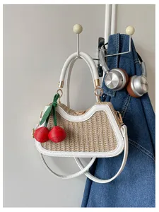 Sac bandouliere en paille tressee d'ete avec charmante cerise rouge pour style plage.