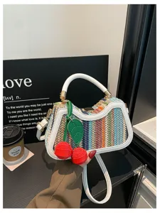 Sac bandoulière chic en paille tissée avec charm cerise mignon, idéal pour la plage d'été.