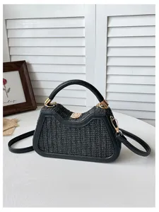 Sac bandoulière noir en paille tissée avec bordure en cuir pour les vacances d'été à la plage.