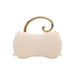 Primo piano della borsa da sera beige in PU con manico curvo dorato e catena sottile.