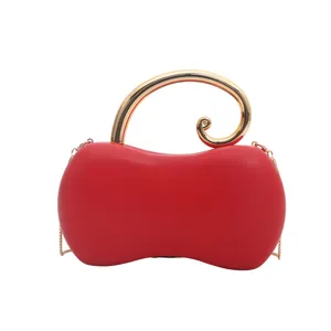 Dettaglio della borsa da sera in pelle PU rossa a forma di arachide con manico dorato.