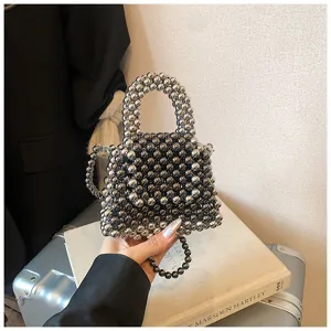 Close-up detail of luxury metallic silver beaded mini handbag with exquisite bead handle and chain.
