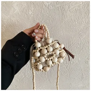 Vista detallada del mini bolso de cuentas de madera hecho a mano con correa y borla.