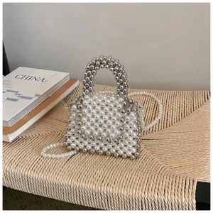 Handmade pearl and silver bead mini handbag detail showcase, elegant woven chair background.