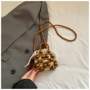 Primer plano de bolso de hombro mini de cuentas de madera hecho a mano con bolsa.