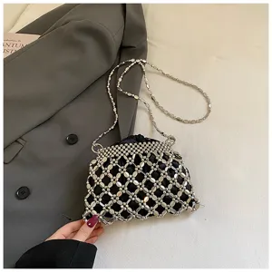 Close-up detail van de handgemaakte kralen raster avondtas met kettingriem en drawstring ontwerp.
