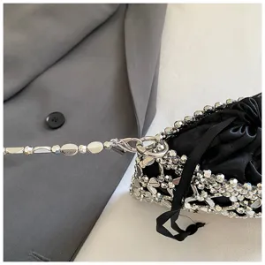 Close-up van zwarte kraal trekkoord tas met zilveren metalen ketting strap detail.