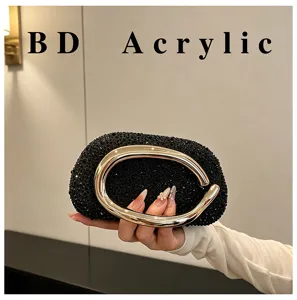 Elegant black rhinestone evening clutch with large gold metallic handle for women parties.