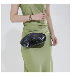 Detailed view of marble acrylic hard clutch bag with metal chain strap for women evening party.