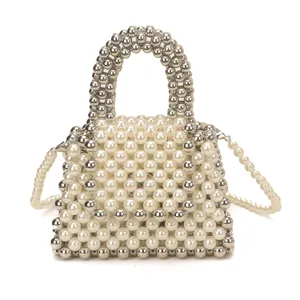 Detail view of a handmade pearl and silver beaded mini handbag with crossbody chain strap.