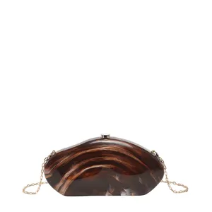 Brown acrylic hard-shell clutch bag with gold chain strap for evening party and casual chic style.