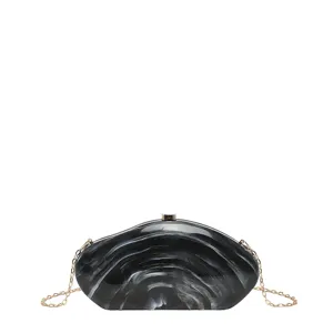 Detailed view of the black and white marble acrylic hard shell evening clutch with gold chain.