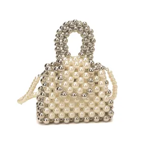 Close-up detail of handmade beaded handbag with white faux pearls and metallic silver beads.
