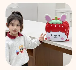 Detailed view of cute cartoon kids EVA school backpack with lovely strawberry design and child model.