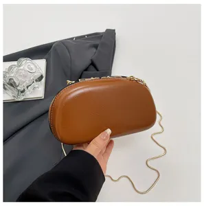 Detailaufnahme der stilvollen braunen PU Leder Hartschalen Abendtasche mit goldener Kette.