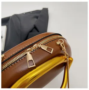 Braune PU Leder Handtasche Detail mit goldenem Metallgriff, Doppelreißverschluss Kette.