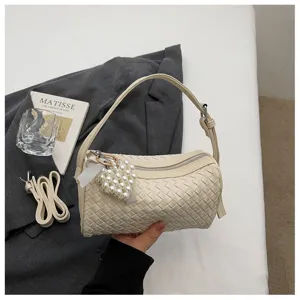 Beige woven cylinder shoulder bag with pearl heart pendant and chic daily aesthetic design.