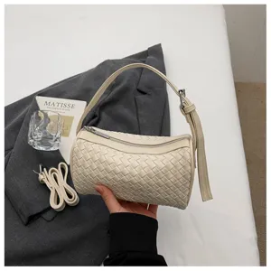 Beige woven cylinder handbag detail, stylish PU leather shoulder bag with zipper closure.