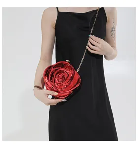 Detailed view of the shiny red acrylic rose clutch bag with gold chain strap for evening events.