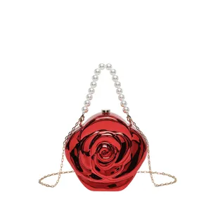 Detailed view of the glossy red acrylic rose clutch handbag with pearl handle and gold chain.