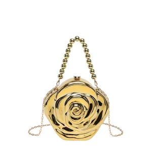 Gold rose acrylic evening bag detail, glossy finish texture, metal chain strap close up view.