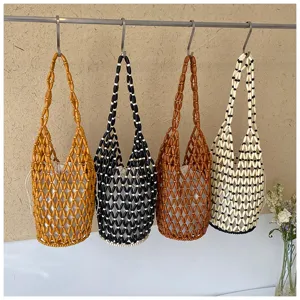 Close-up detail of stylish beaded hollow bucket bags hanging neatly on hooks for resort wear.