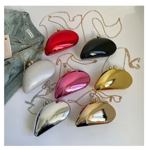 Detailansicht von bunten, metallischen mangoformigen Hartschalen-Abendtaschen mit Ketten.