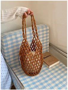 Handmade wooden beaded hollow tote bag detail, woven shoulder bag with white inner pouch.