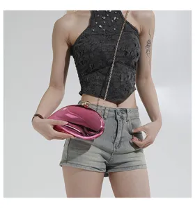 Detailansicht der rosa glänzenden mango-förmigen Hartschalen-Abendtasche mit Kette.