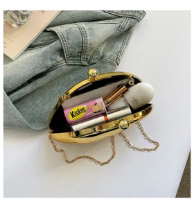 Goldene metallische Clutch Detail, Abendtasche Innenansicht mit Kettengurt und glänzendem Finish.