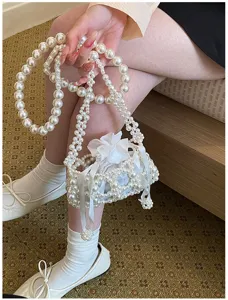 Exquisites Detail einer weißen Kunstperlen Perlenhandtasche, elegantes Abendaccessoire.