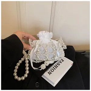 Elegante weiße perlenbesetzte Eimer Abendtasche mit großer Perlenkette und feinem Band.