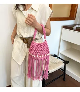 Detail shot of a stylish pink macrame bucket bag featuring wooden beads and long fringe.