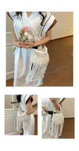 Detailed view of white woven macrame fringe bucket bag worn by model, resort beach style.