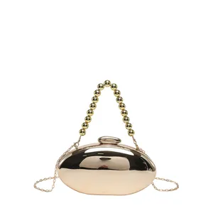 Gold metallic oval clutch bag with beaded handle and chain strap for women evening party.
