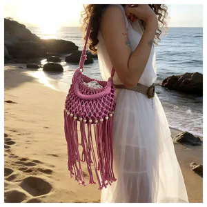Pink woven fringe bucket bag, hollow beach handbag, stylish summer vacation shoulder bag.