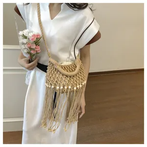 Detailed view of beige woven fringe bucket bag with hollow design and wooden bead accents.