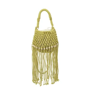 Close-up of woven fringe bucket bag details, featuring delicate macrame pattern and wood beads.