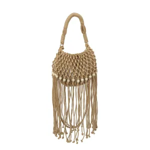 Close-up of beige woven macrame handbag with hollow pattern, white beads, and elegant fringe tassels.