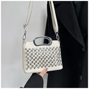 Détail de sac à main strass avec cristaux scintillants et poignée en métal argenté.