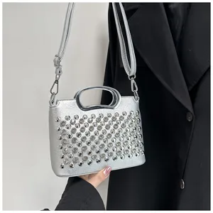Détail de sac à main argenté en strass, poignée en métal, élégant accessoire de mode.