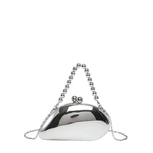 Silberne metallische Abendtasche in Mango-Form mit harter Schale und Perlenkette.