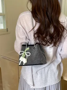 Black rhinestone chain bucket bag worn on shoulder, stylish women handbag main view.
