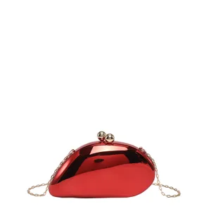 Rote, mangoförmige Hartschalen-Abendtasche mit Goldkette und Kugelverschluss elegant.