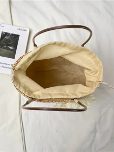 Summer straw woven handbag with brown handles and flower decor, casual beach bucket bag.
