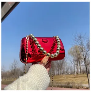 Borsa da sera lucida in acrilico rosso con elegante tracolla a catena di perle.