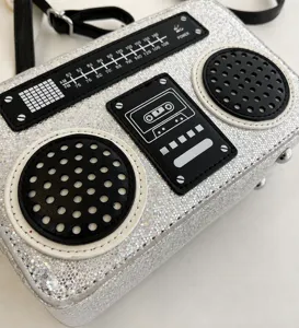 Detailansicht der silbernen Glitzer-Radio-Umhängetasche mit Kassetten- und Zifferblatt-Motiv.