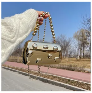 Splendida borsa clutch metallica dorata con elegante tracolla a catena di perle per serate chic.