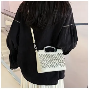 Vue détaillée du sac à bandoulière élégant en strass doté d'une poignée métal et de clous.