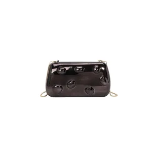 Primo piano dettagliato della borsa clutch metallica lucida con superficie a bolle 3D e catena.